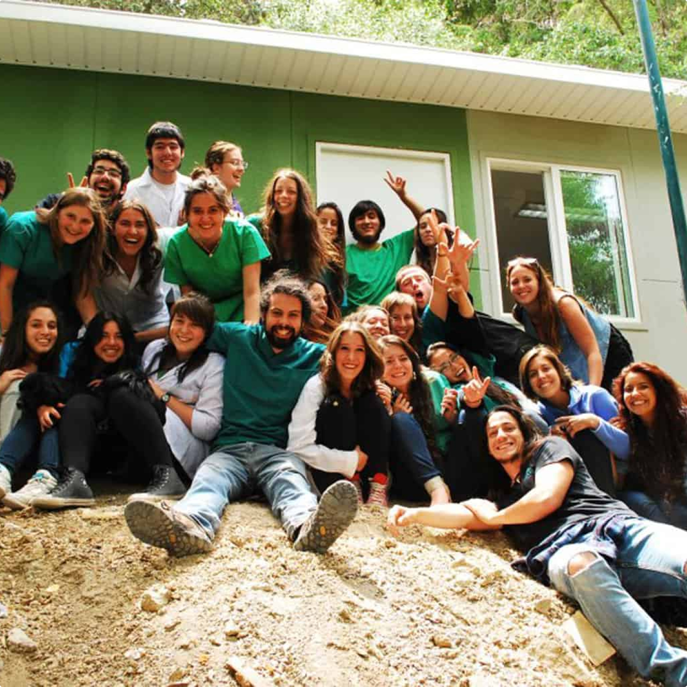 A bunch of people smiling in front of a construction site.